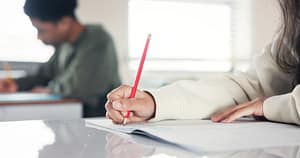 Writing, hands and teenage girl in school, education and exams with scholarship. Closeup, person or students in classroom, academy and knowledge with test, ideas and creativity with notes or learning